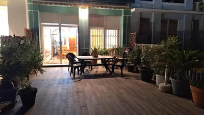 a patio with a table and chairs and potted plants at Apartamento con gran terraza frente al Mar playa Valencia in Valencia
