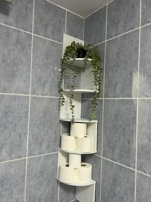 a bathroom with a shelf with towels and a wreath at La Llum de Serra in Serra