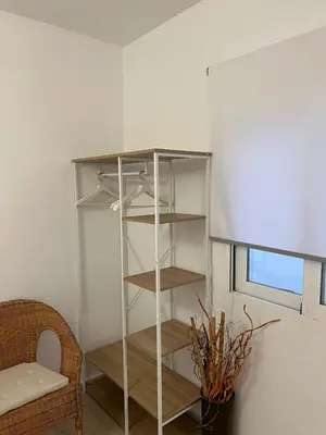 a book shelf in a room with a chair and a window at La Llum de Serra in Serra
