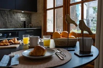 a table with a plate of bread and orange juice at Prime Location, Bright & Cozy Apartment in Valencia