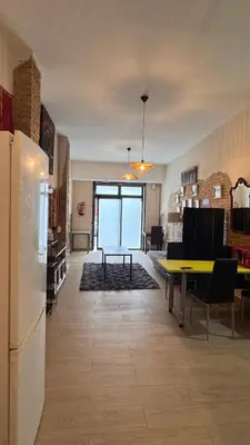 a living room with a refrigerator and a table at Gran Loft en planta baja en el Centro de Valencia in Valencia