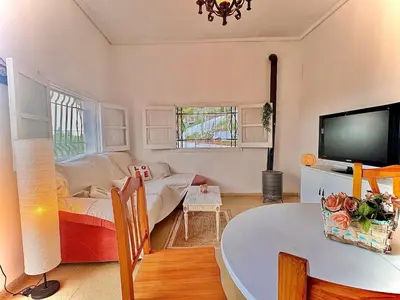 a living room with a couch and a tv at El Cortijo a cielo abierto entre montañas in Estivella