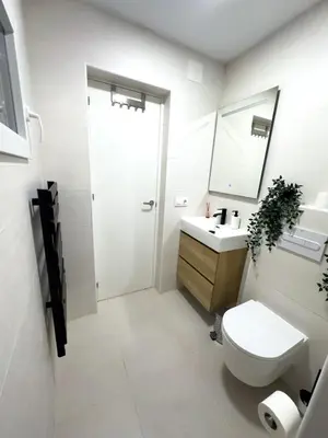a bathroom with a toilet and a sink and a mirror at Apartamento bajo acogedor, moderno, cerca del Mar in Valencia