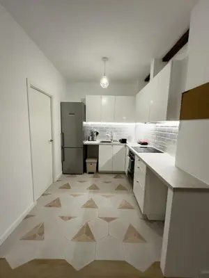a kitchen with white cabinets and a tile floor at Apartamento bajo acogedor, moderno, cerca del Mar in Valencia