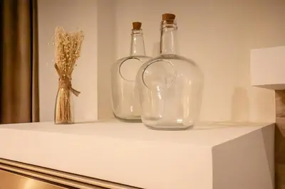 three glass bottles sitting on top of a counter at Suite Ciudad de las Ciencias y Puerto - Manolito 4 in Valencia