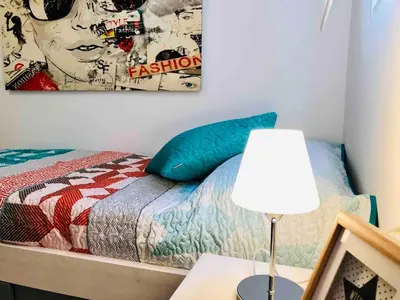 a bedroom with a bed with a painting on the wall at Apartment near the beach and the City of Sciences in Valencia