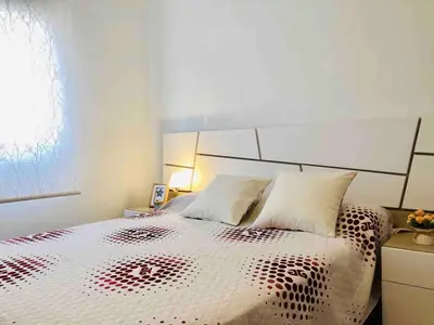 a bedroom with a white bed with a black and white comforter at Apartment near the beach and the City of Sciences in Valencia