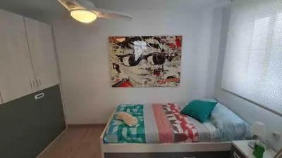 a bedroom with a bed with a painting on the wall at Apartment near the beach and the City of Sciences in Valencia