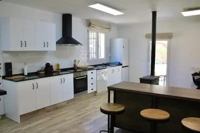 a kitchen with white cabinets and a wooden counter top at Casa Principal Finca Mas el Bravo in Caudiel