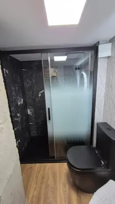 a bathroom with a toilet and a glass door at Excepcional Amplio Apartamento Industrial Fallas hasta 6, wifi gratis cuna in Valencia