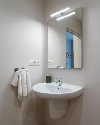 a white bathroom with a sink and a mirror at Viva Valencia Apartments - Arte & Reflejos in Valencia