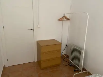 a room with a wooden dresser and a door at Clau al castell apartament in Serra