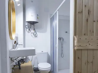 a bathroom with a white toilet and a sink at Winahost Loft Colón in downtown Valencia in Valencia
