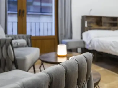 a hotel room with a bed and a table and chairs at Winahost Loft Colón in downtown Valencia in Valencia