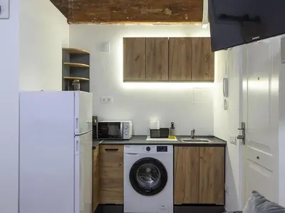a kitchen with a washing machine and a refrigerator at Winahost Loft Colón in downtown Valencia in Valencia