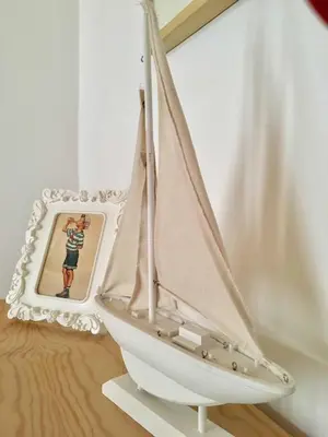 a small sail boat on display next to a mirror at Apartment next to the beach in Valencia