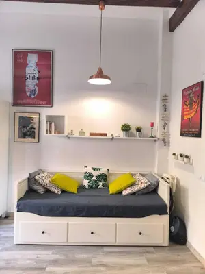 a bedroom with a bed with yellow pillows on it at Encantador Loft Cabañal · Playa Las Arenas in Valencia