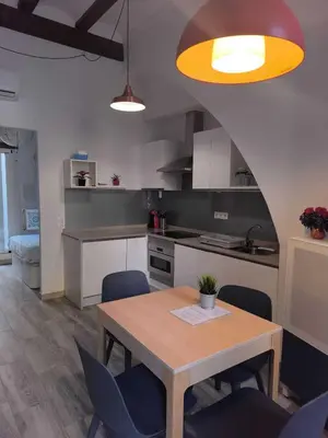 a kitchen with a wooden table and blue chairs at Encantador Loft Cabañal · Playa Las Arenas in Valencia