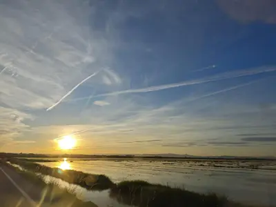 a sunset over a river with the sun in the sky at SeaSuites Yellow - Loft cerca del mar en Cullera in Mareny de San Lorenzo