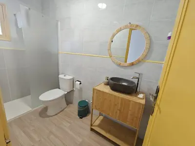 a bathroom with a sink and a toilet and a mirror at SeaSuites Yellow - Loft cerca del mar en Cullera in Mareny de San Lorenzo