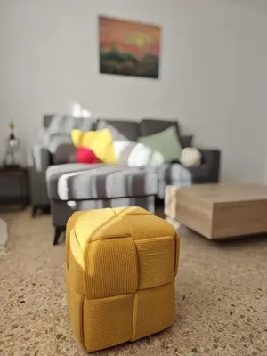 a living room with a couch and a yellow ottoman at SeaSuites Yellow - Loft cerca del mar en Cullera in Mareny de San Lorenzo