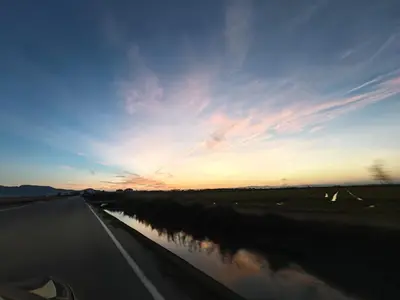 a view from a car driving down a road at sunset at SeaSuites Yellow - Loft cerca del mar en Cullera in Mareny de San Lorenzo