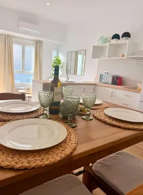 a wooden table with plates and wine glasses on it at Loft acogedor y luminoso in Valencia