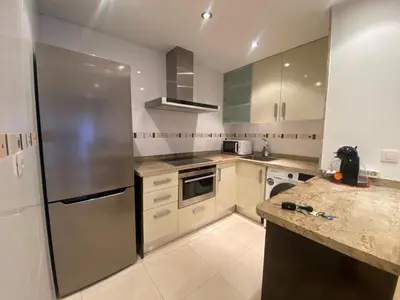 a kitchen with white cabinets and a stainless steel refrigerator at Apartamento en primera línea de playa 38 in Valencia