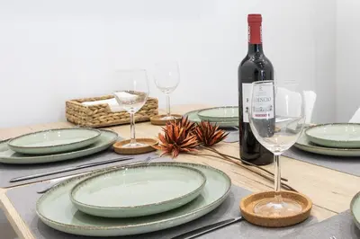 a table with green plates and a bottle of wine at Modern & Stylish Apartment Close to the Beach in Valencia