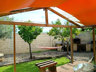 an orange umbrella and a hammock in a backyard at La Villa Blanca in Pedralba