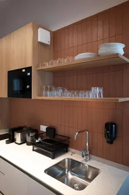 a kitchen with a sink and a counter with plates and glasses at Mon Suites San Pedro in Valencia