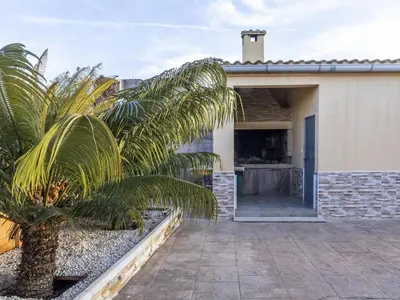 a palm tree in front of a house at Winahost Villa Unión in Puebla de Vallbona