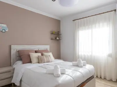 a bedroom with a large white bed with a window at Winahost Villa Unión in Puebla de Vallbona