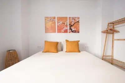 a bedroom with a large white bed with orange pillows at Casa Estrellita Boutique Apartment in Valencia