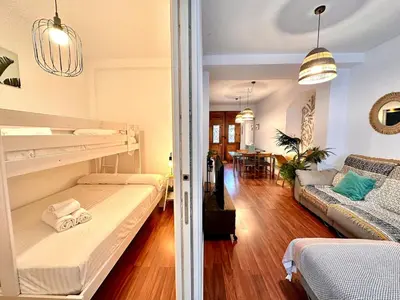 a bedroom with two bunk beds and a living room at Padre Anton seasonal apartment in Valencia