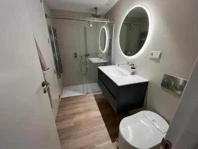 a bathroom with a toilet and a sink and a mirror at Bright spacious luxury apartment in Valencia