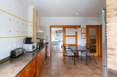 a kitchen with a table and a dining room at Villa Azahar - Mediterranean Retreat in Benifayó