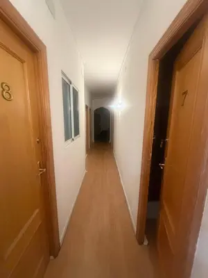 a hallway with a long corridor with white walls and wooden doors at Danner in Valencia