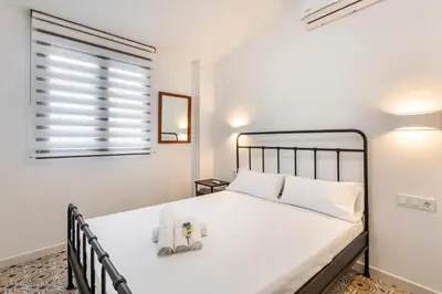 a bedroom with a large white bed with towels on it at GuestReady - Traditional House near Malvarrosa in Valencia
