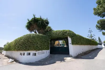 a building with a gate with a tree on top of it at Tiny House Long-term en remote work near Valencia in Torrent