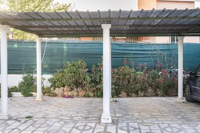 a pergola in front of a garden with flowers at Tiny House Long-term en remote work near Valencia in Torrent