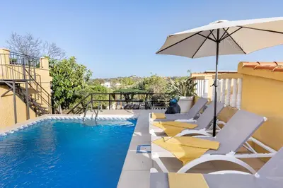 a swimming pool with lounge chairs and an umbrella at Tiny House Long-term en remote work near Valencia in Torrent