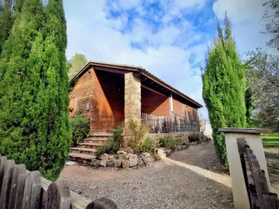 a wooden house with a fence and trees at Casa de Madera I - Naturaleza y Experiencias in Bicorp