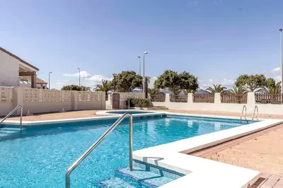 a large swimming pool with blue water at Chalet adosado junto al mar en Almarda Sagunto in Almarda