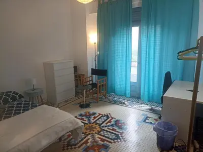 a bedroom with a bed and a blue curtain at Habitación Grande Ruzafa Centro in Valencia