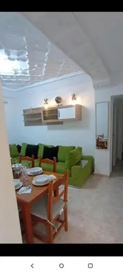 a living room with a table and a green couch at Valencia city in Valencia