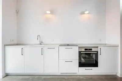 a white kitchen with white cabinets and a sink at Casa Reina Nina in Valencia