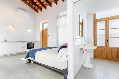a white bedroom with a bed and a sink at Casa Reina Nina in Valencia