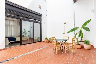 a patio with a table and chairs on a brick floor at Casa Reina Nina in Valencia