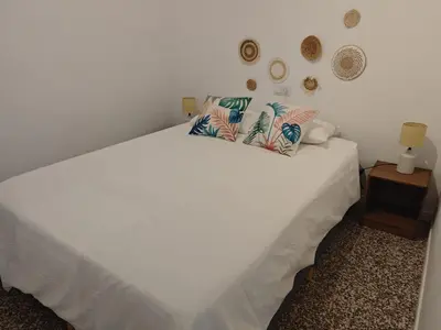 a bedroom with a white bed with a light on it at SeaSuites Blue - Casa cerca del mar en Cullera in Mareny de San Lorenzo